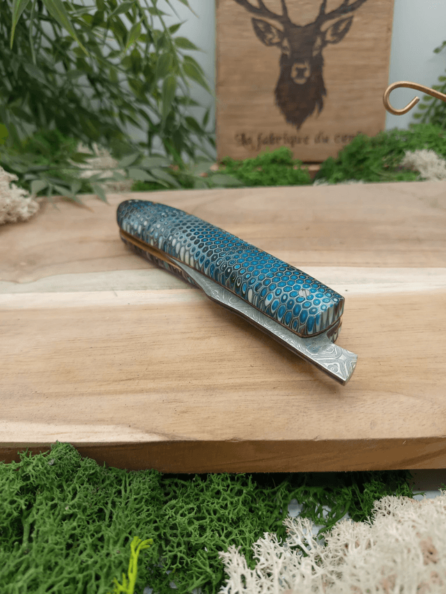 Couteau pliant artisanal “Le Cerf” – Édition Prestige n°003 – lame damas VG10 – manche résine époxy nid d’abeille – platines laiton et cuivre